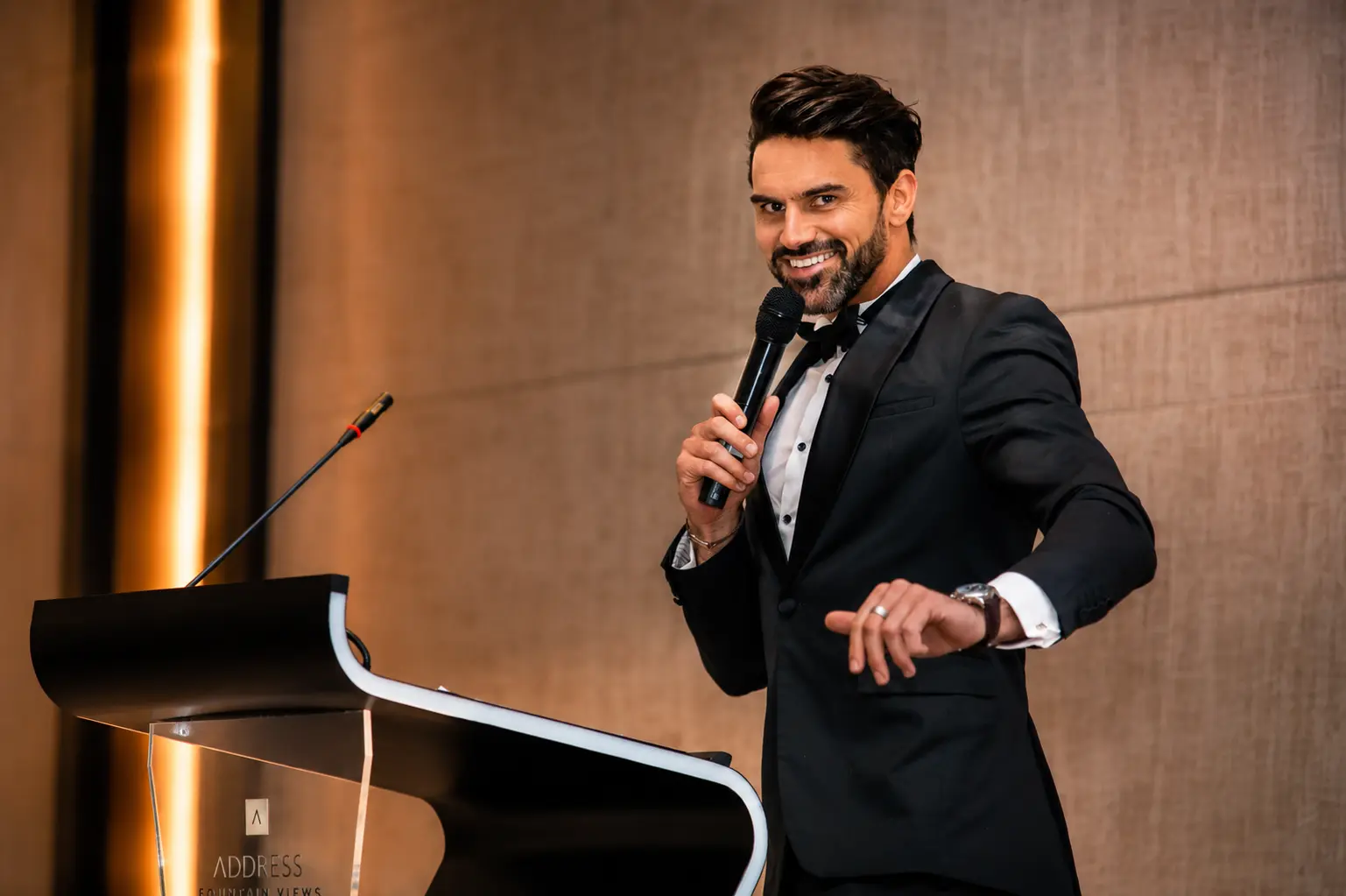 Corporate comedian Dubai performing clean comedy and hosting a business event from the stage at a corporate conference.