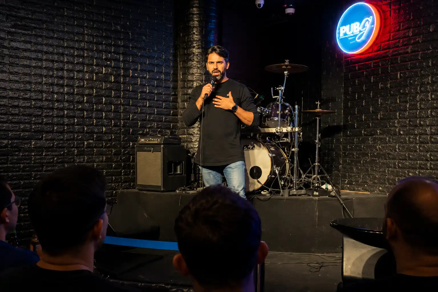 Corporate comedian performing live on stage with audience engagement at a Dubai comedy club and private event venue.